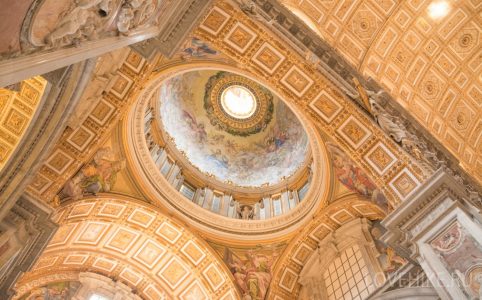 Vatican City, Rome, Italy - February 23, 2019: Interior ceiling of the Basilica of the Holy Apostle Peter in the Vatican, yellow color dome inside. Famous landmark in Rome.